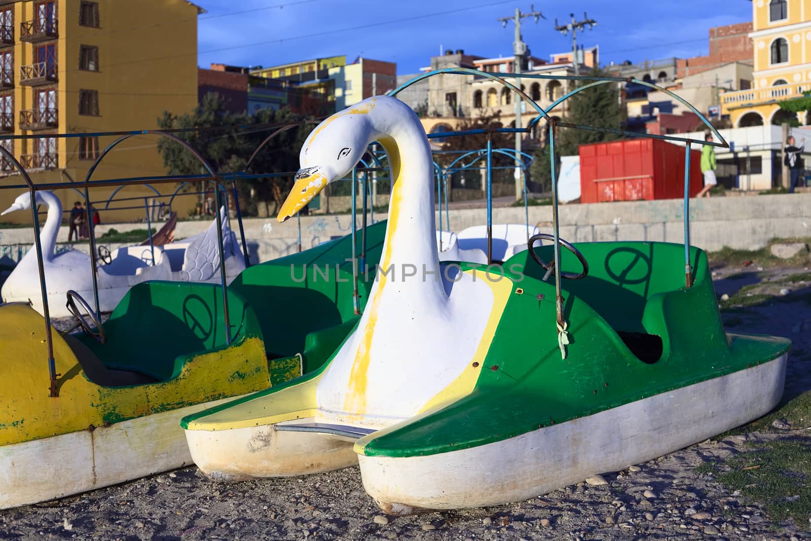 COPACABANA, BOLIVIA - OCTOBER 17, 2014: White and green swan shaped pedal boat on the shore of Lake Titicaca in the small tourist town on October 17, 2014 in Copacabana, Bolivia. Many pedal boats and kayaks are available for rent along the coastline of Copacabana. 