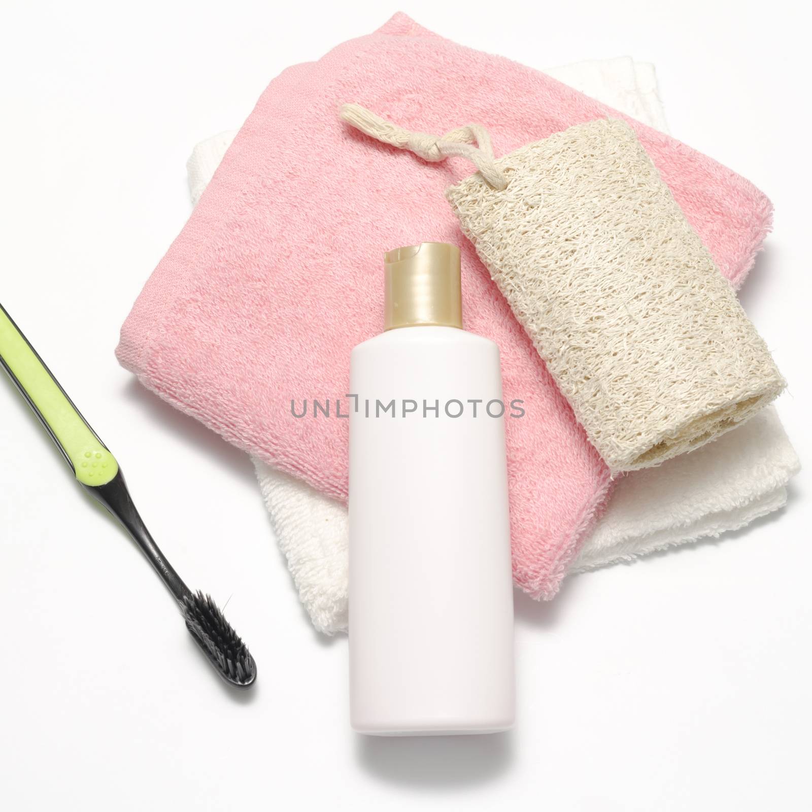 towel loofah liquid soap and toothbrush on a white background