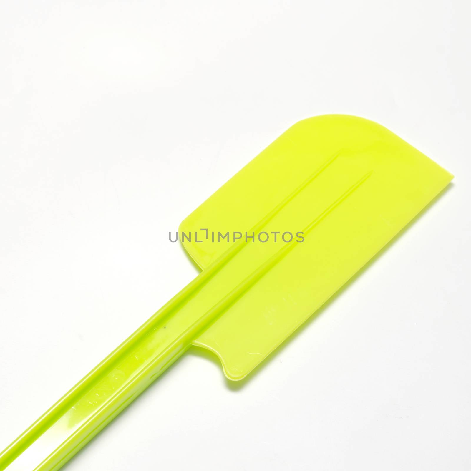 green plastic spatula on a white background