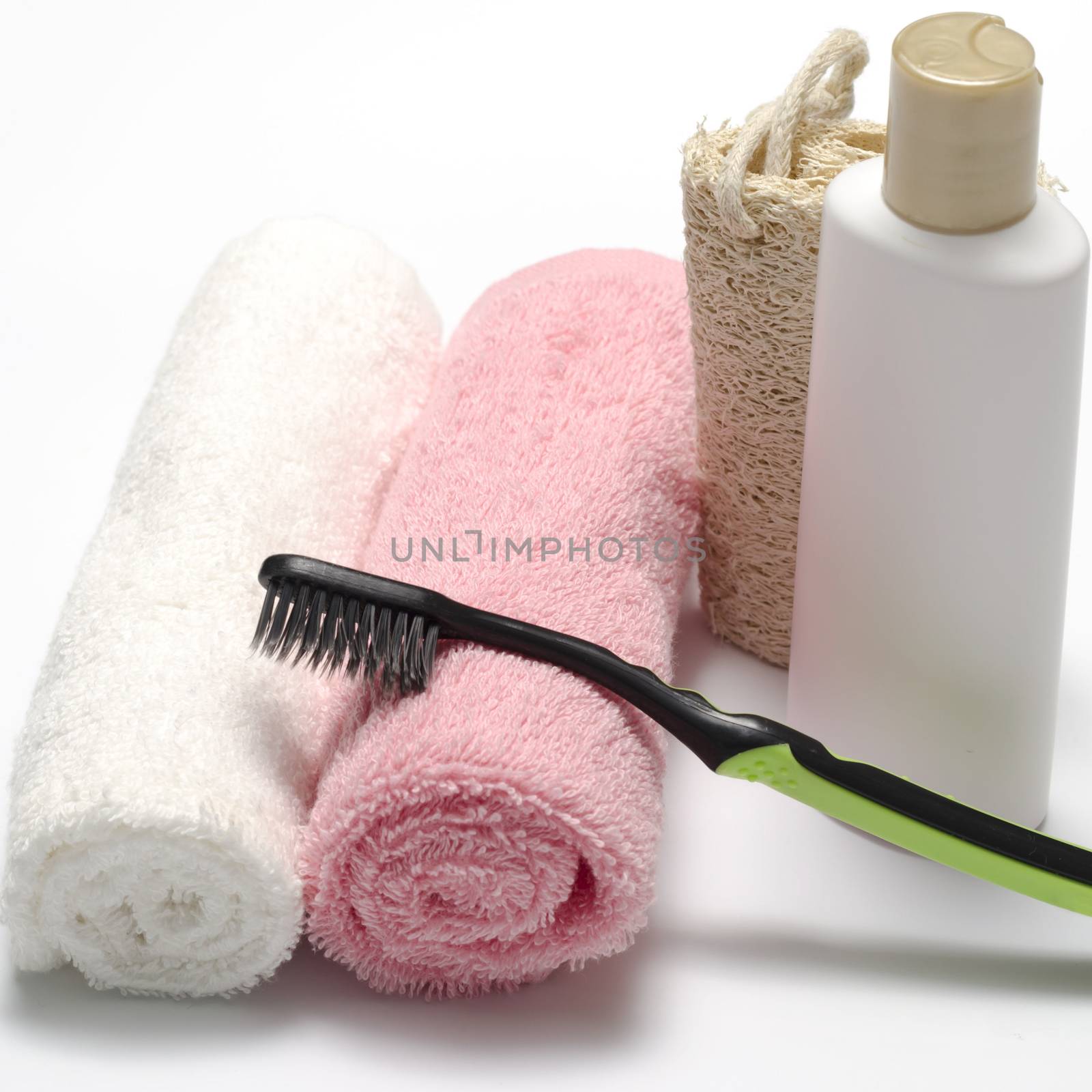 towel loofah liquid soap and toothbrush on a white background