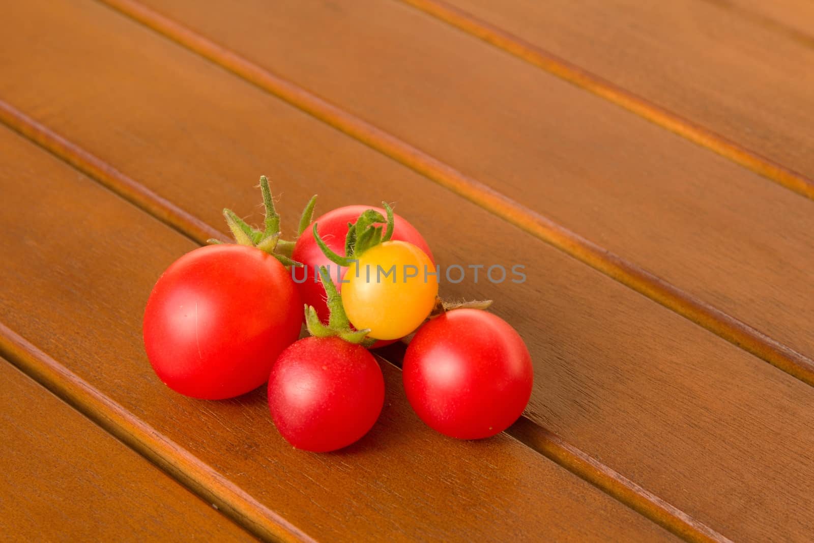 Photo shows a detail of the colourful tomatoes on a table.