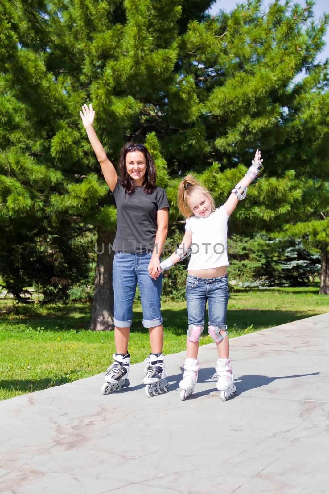 Photo of mother and daughter on roller skates in summer