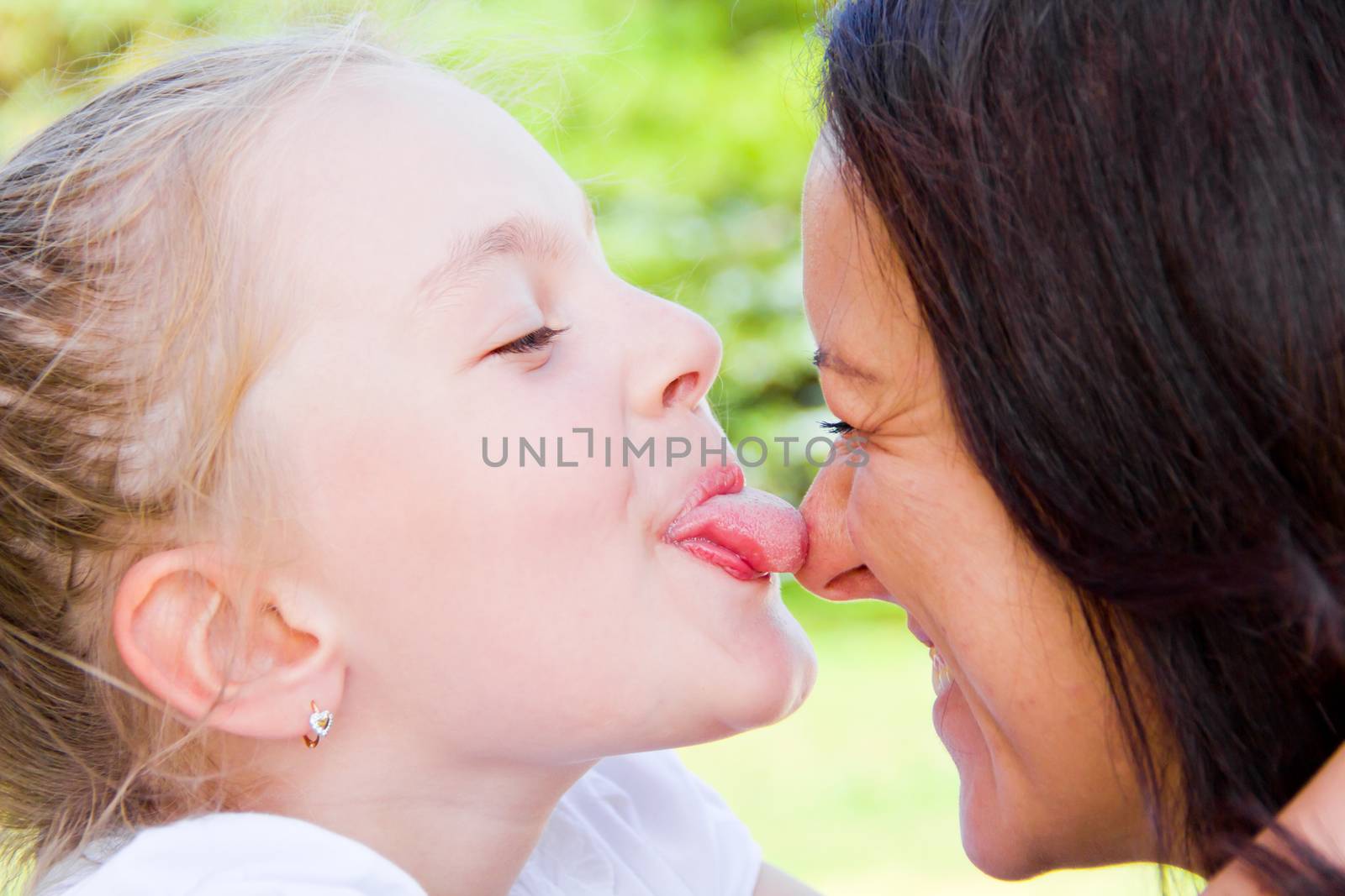 Photo of kissing mother and daughter in summer