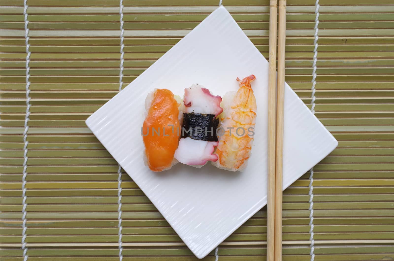 Sushi nigiri in dish with bamboo sticks  by pixbox77