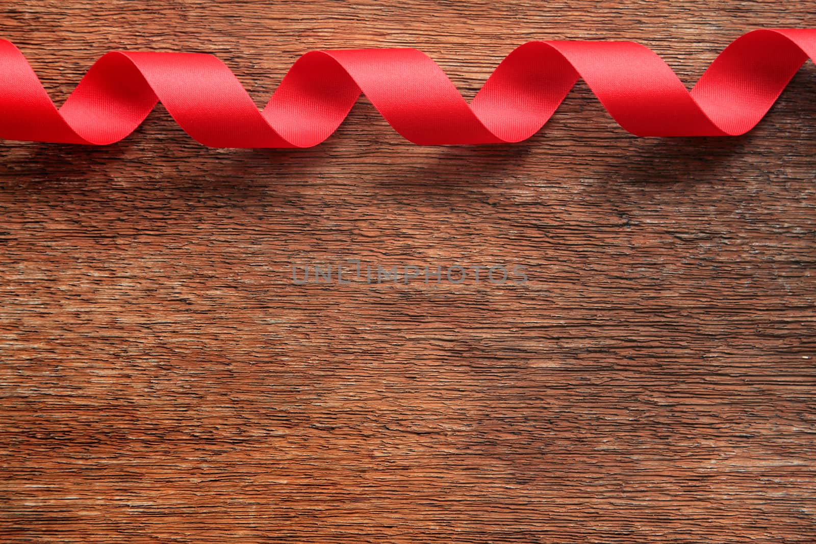 Red Ribbon on Old Wood Background