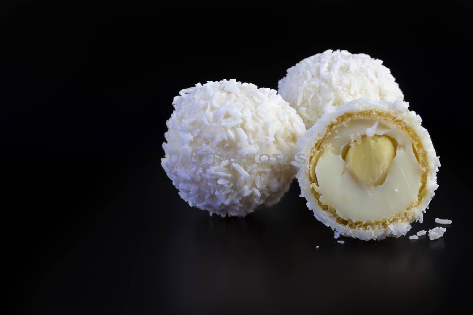 coconut balls on black background by manaemedia