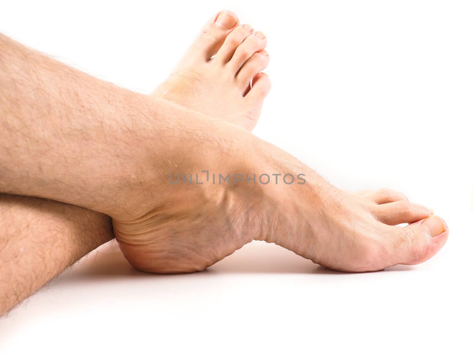 Hairy legs and feet of male person resting by Arvebettum