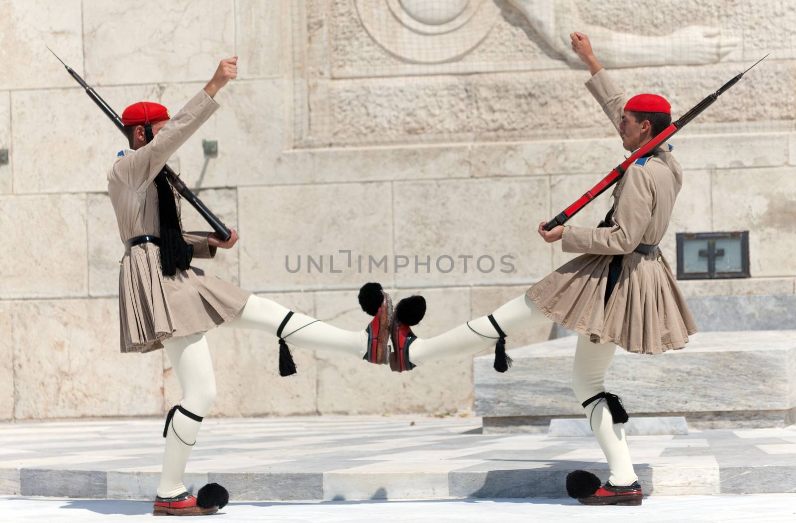 ATHENS, GREECE - JULY 23: Evzones (presidential guards) watches over the monument of the Unknown Soldier in front of the Greek Parliament Building at Syntagma Square on July 23, 2010 in Athens, Greece. Evzoni, is the name of historical elite mountain units of Greek Army.