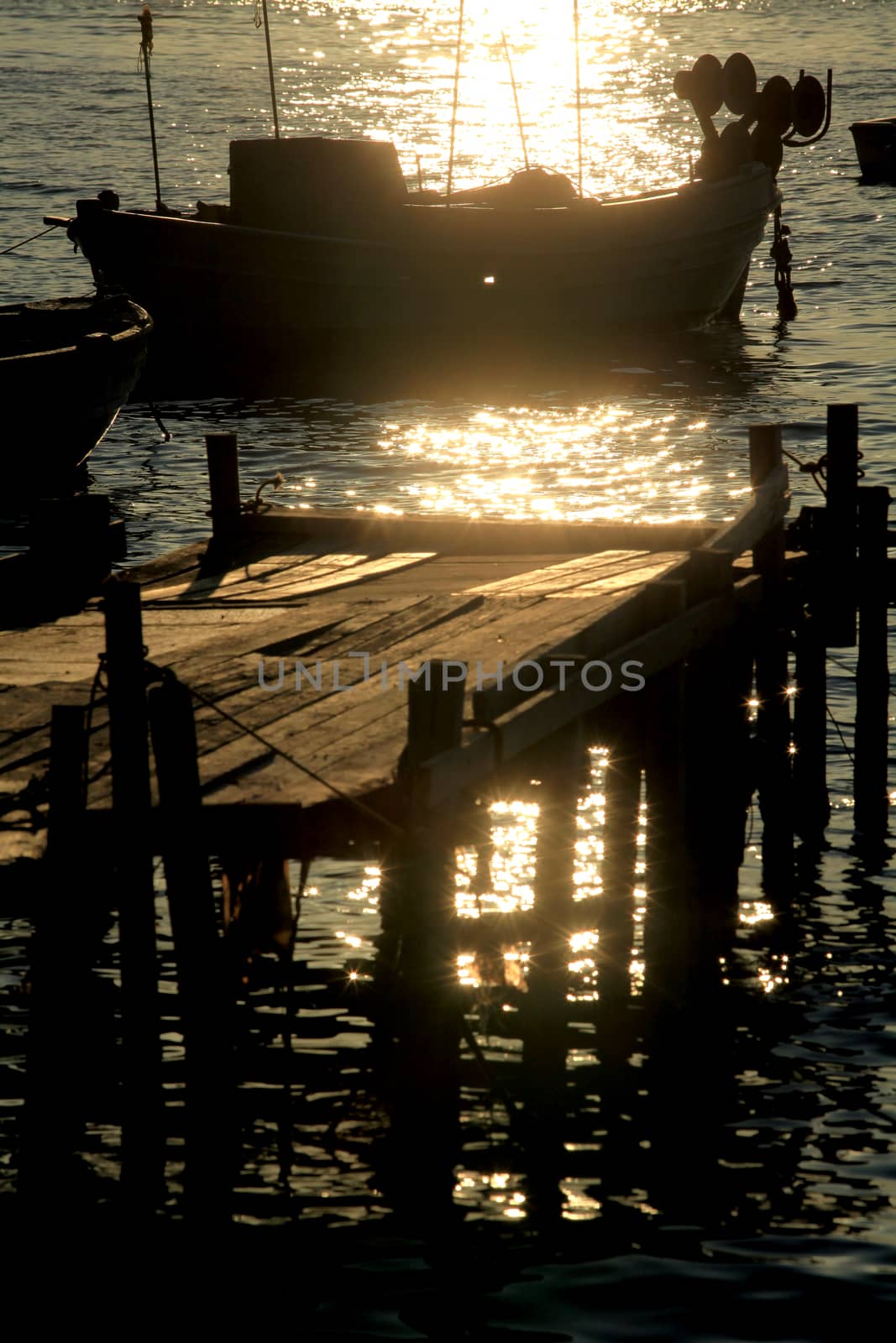 Wooden pier with boats at sunset