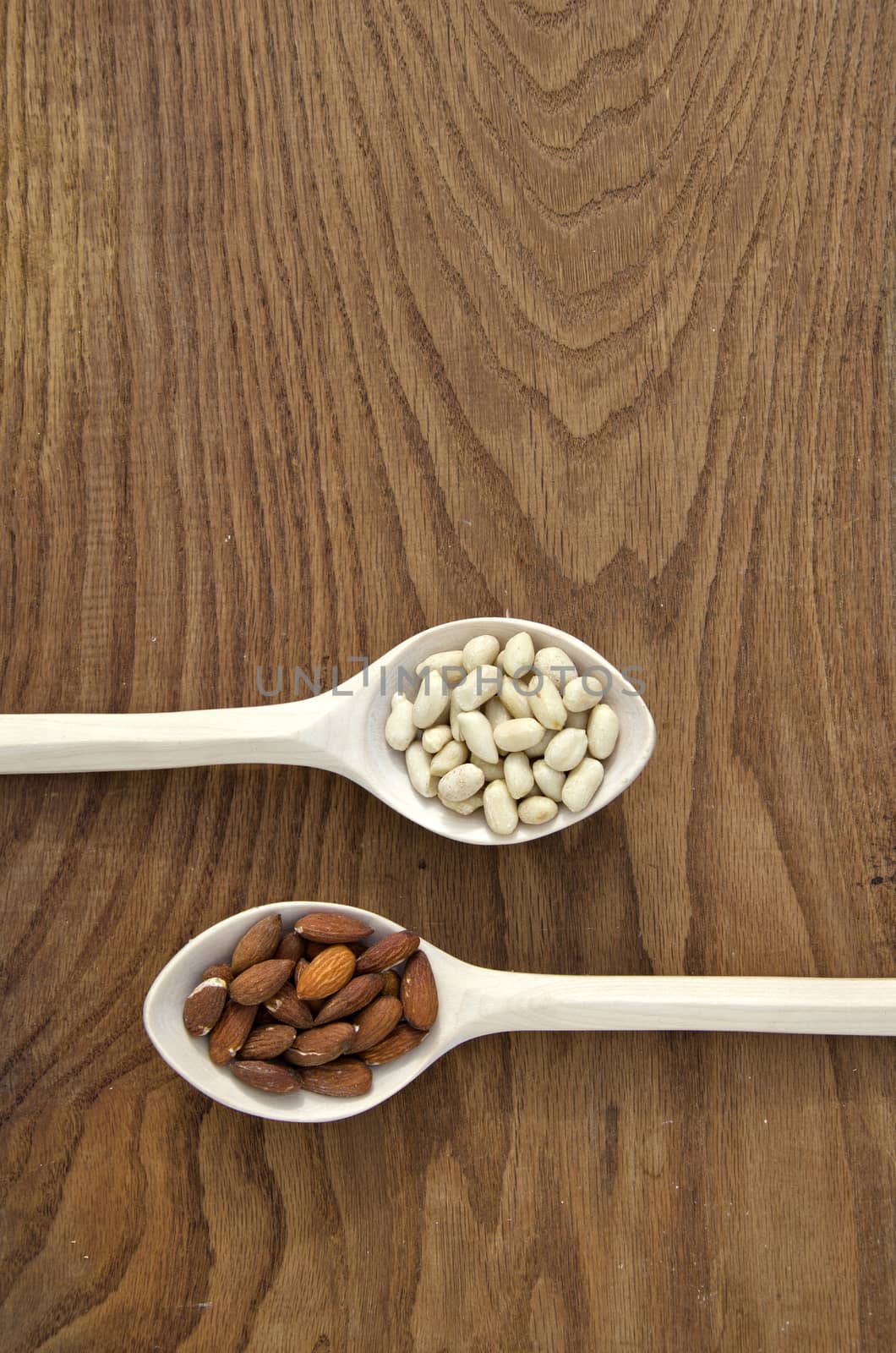 nuts in new wooden spoons on oak plank background. Healthy food