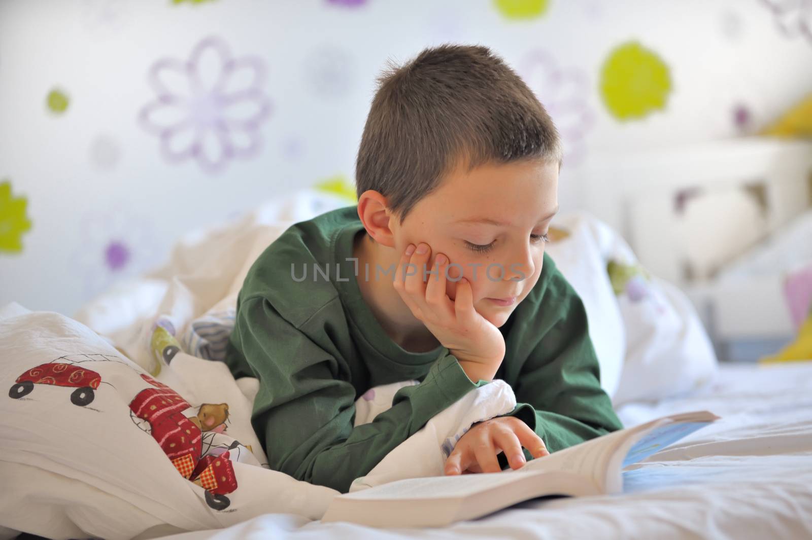 Young Boy Reading a Book in Bed in morning time