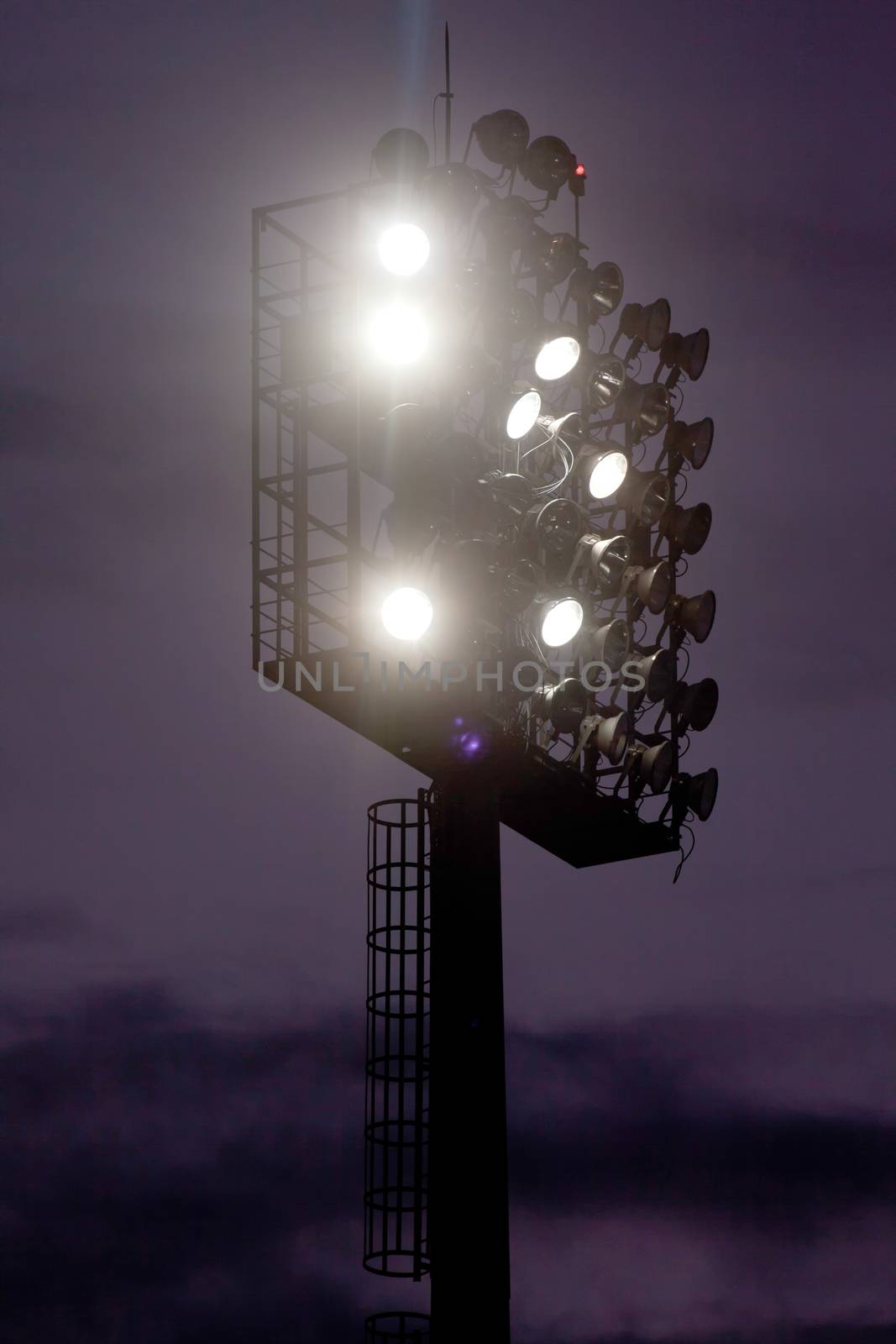 Stadium lights against dark night sky background