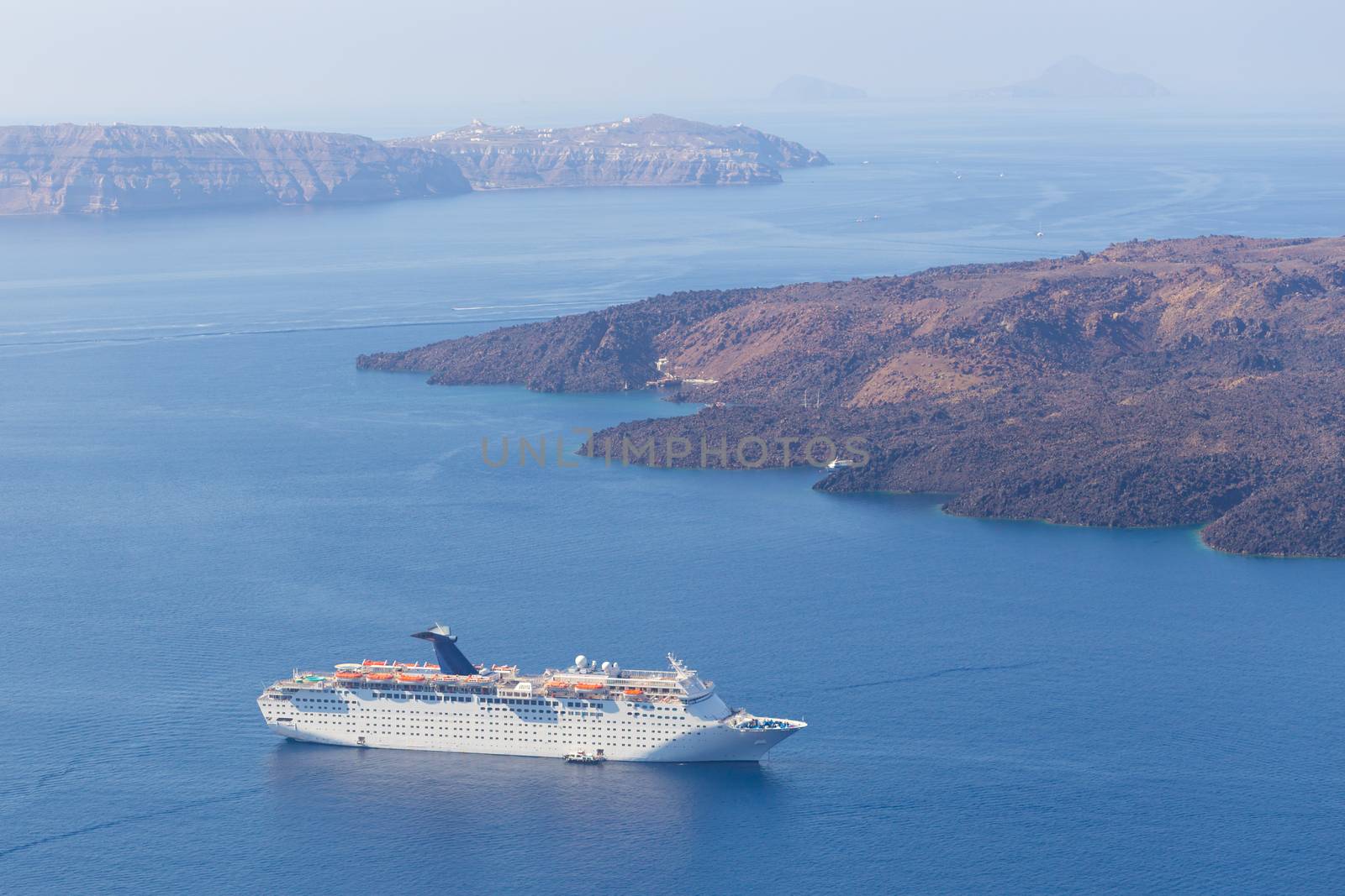 Luxury cruise ship sailing around Santorini island, Aegean sea in Greece.