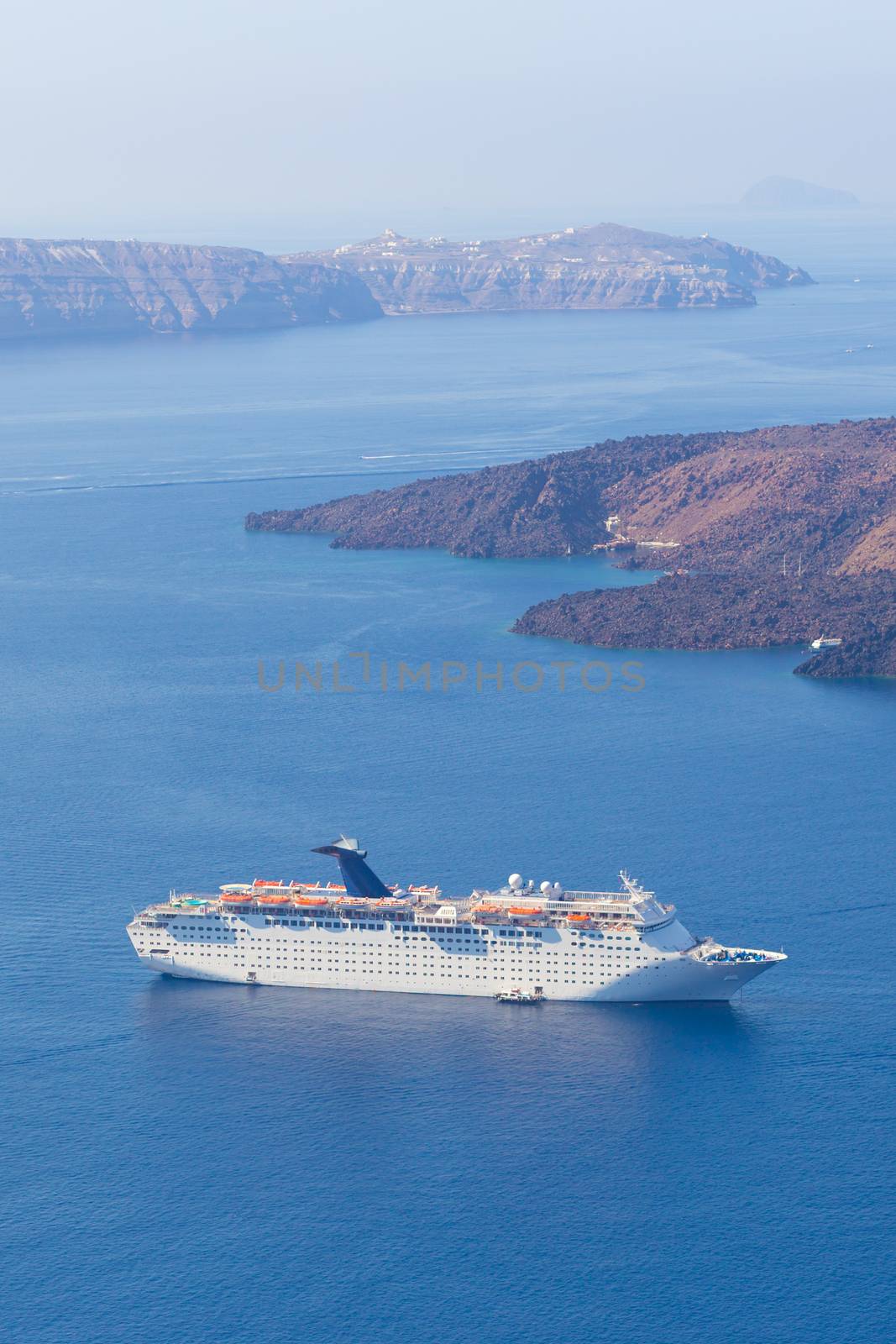 Luxury cruise ship sailing around Santorini island, Aegean sea in Greece.