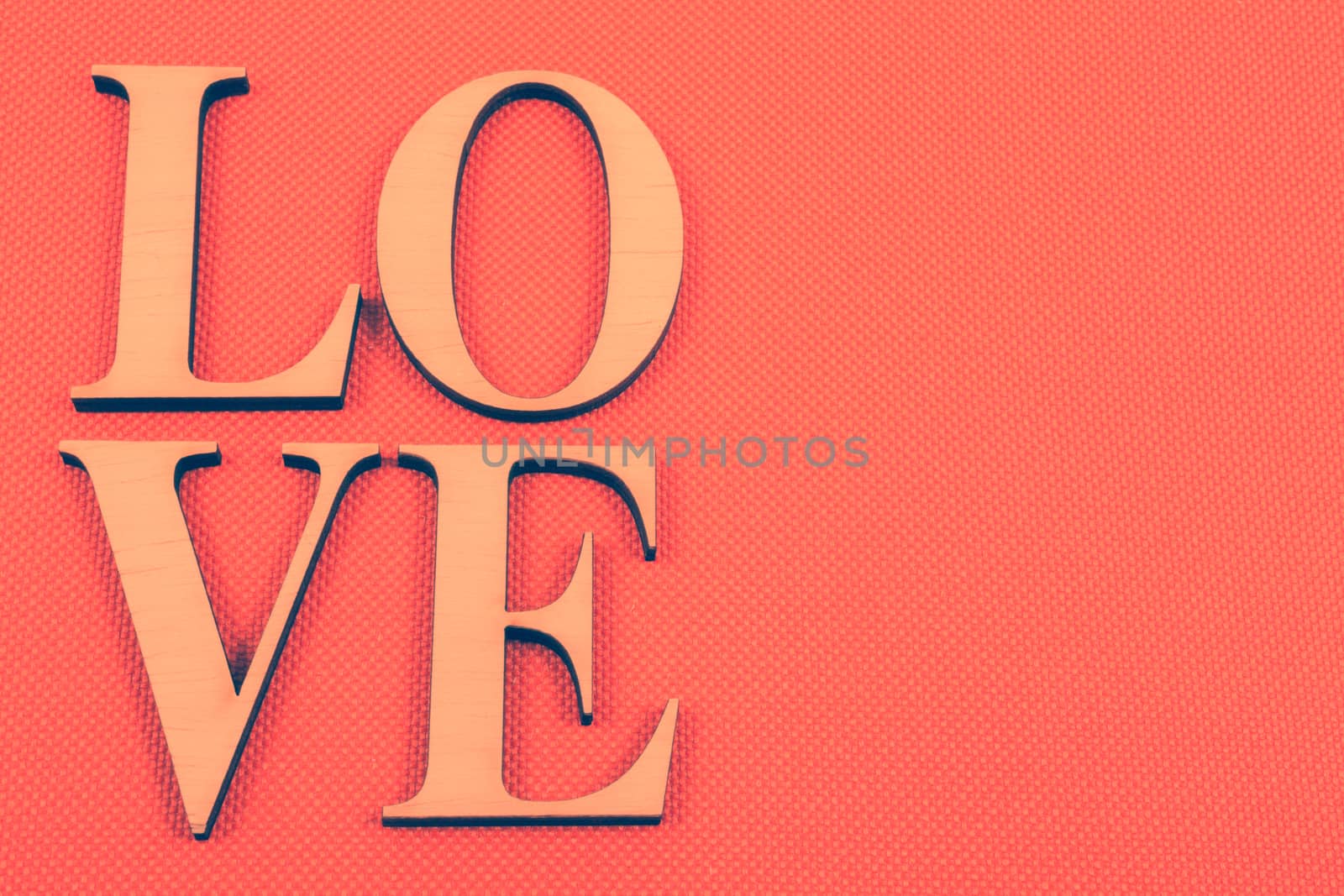 Wooden letters forming word LOVE written on orange background