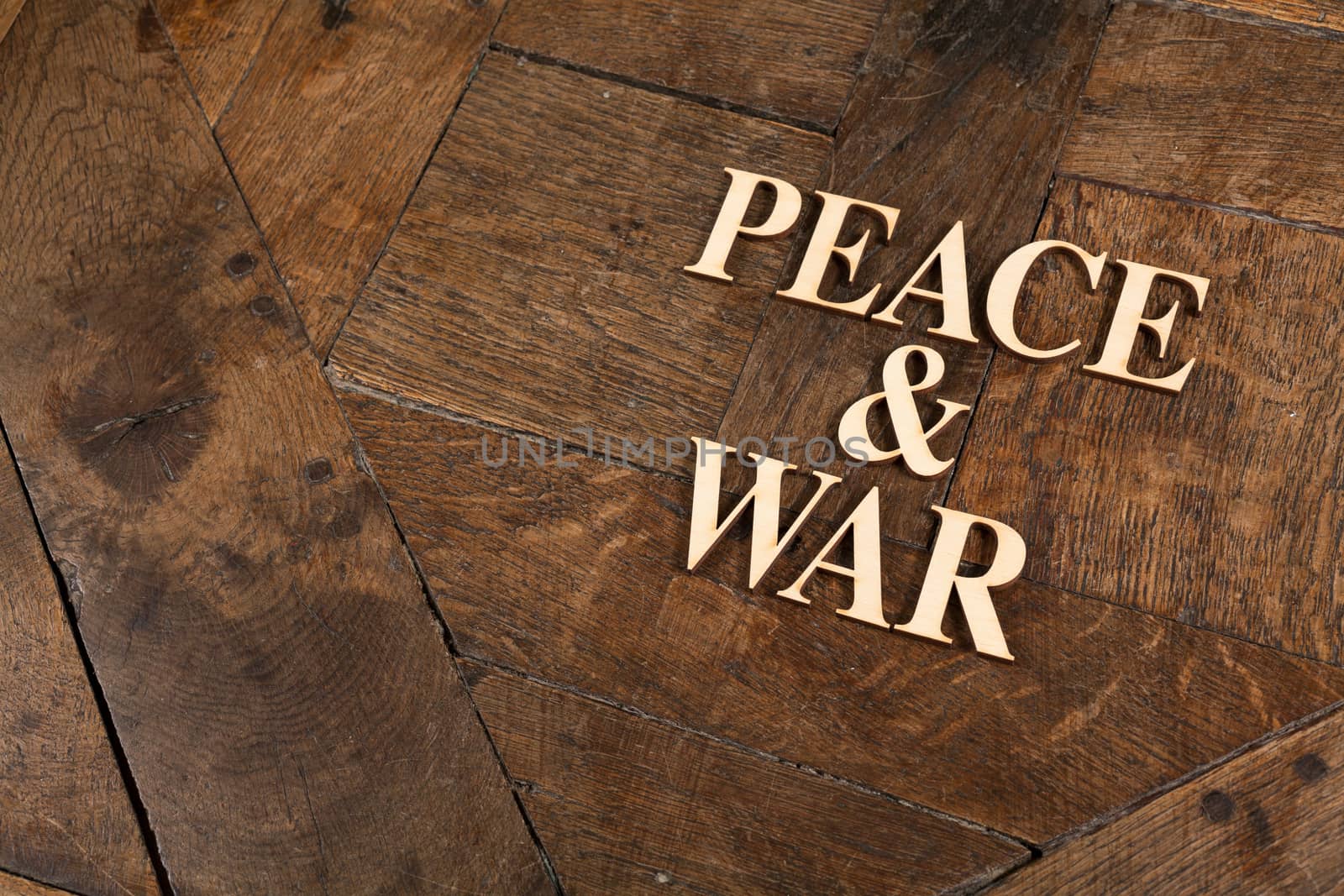 Wooden letters forming words PEACE & WAR written on old vintage wooden plates with space for your own text.