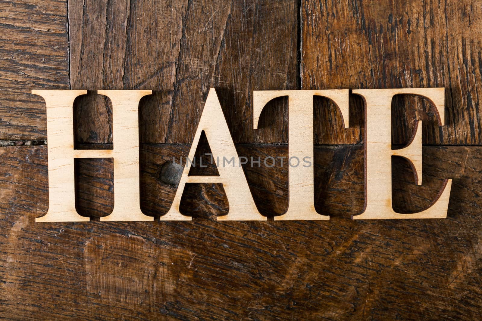 Wooden letters forming word HATE written on old vintage wooden plates