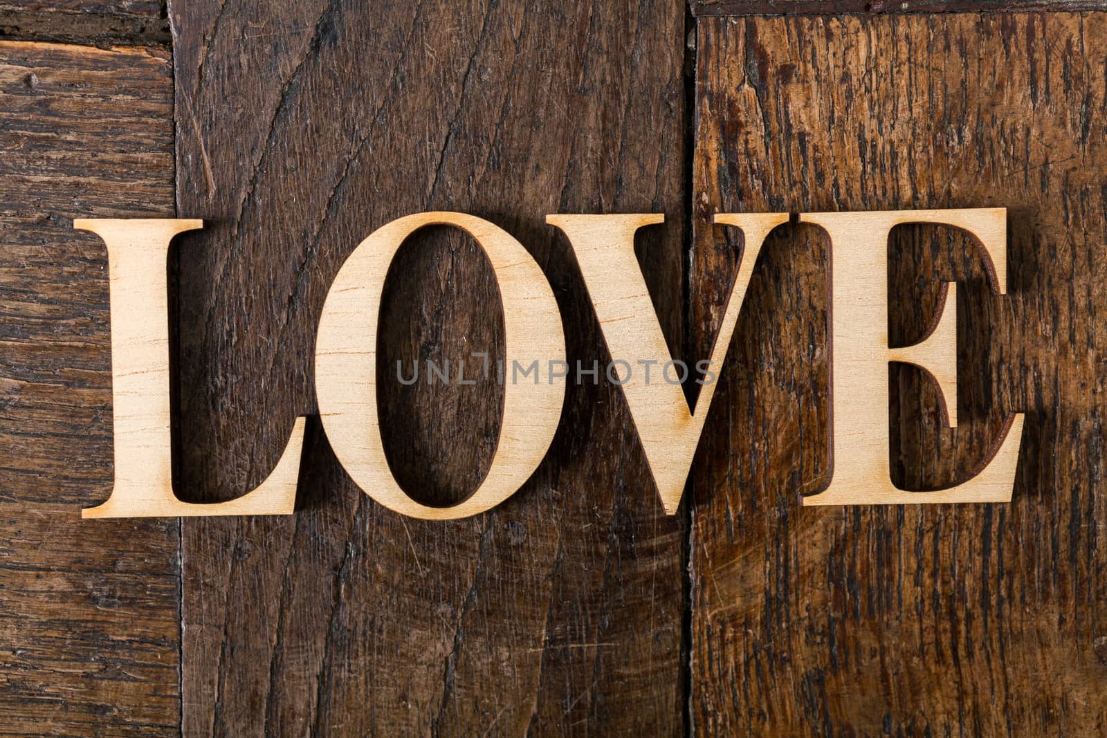 Wooden letters forming word LOVE written on old vintage wooden plates