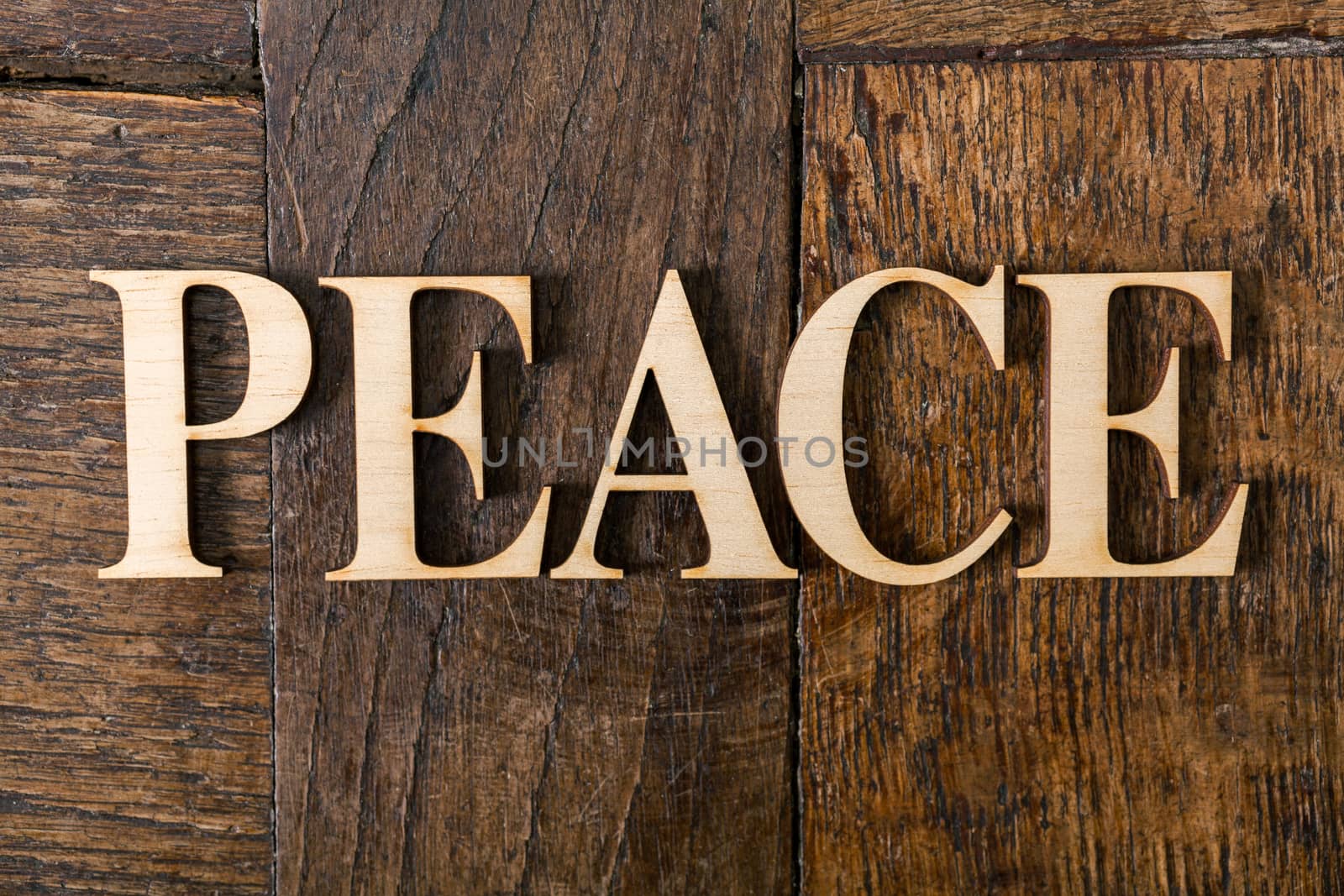 Wooden letters forming word PEACE written on old vintage wooden plates