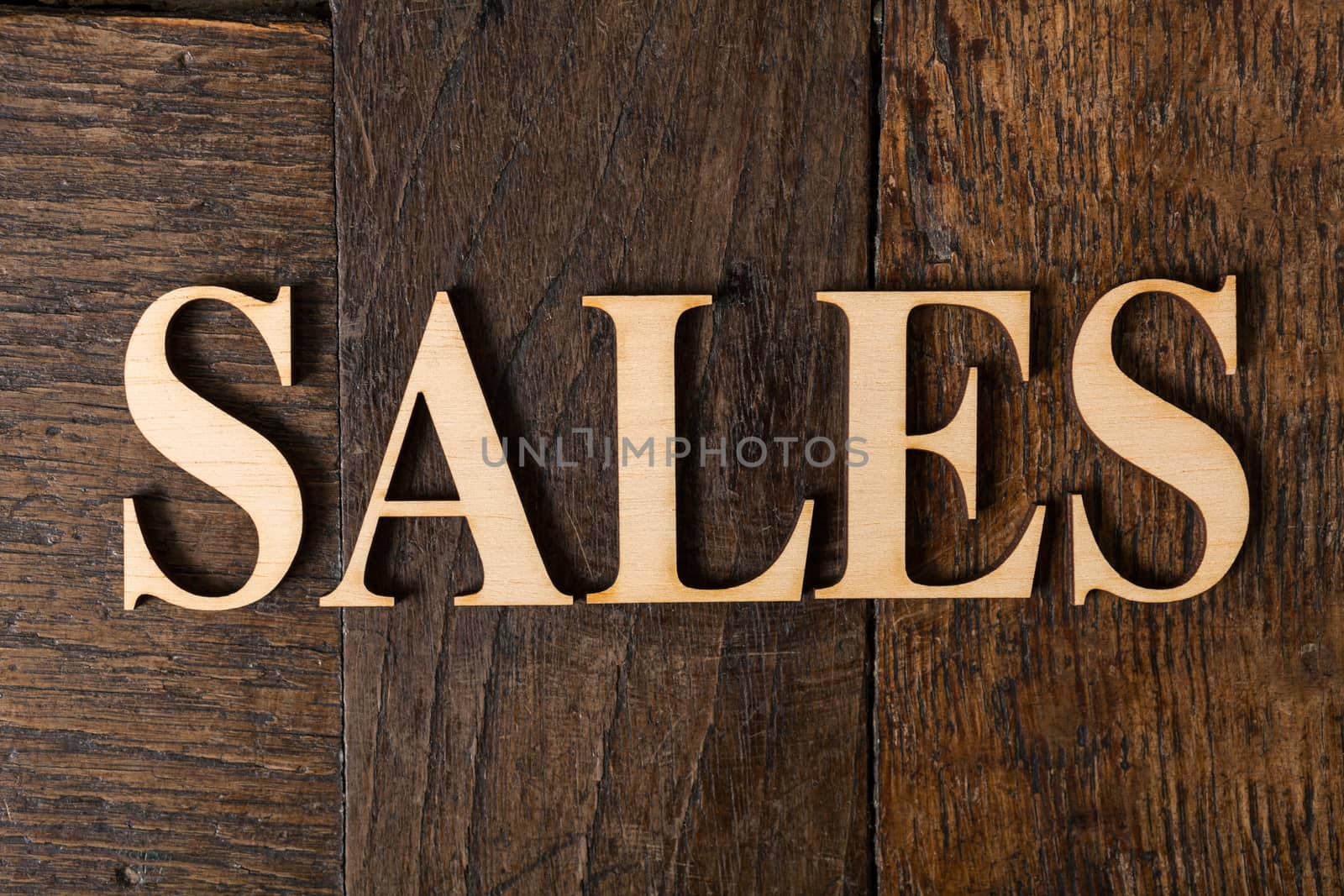 Wooden letters forming word SALES written on old vintage wooden plates
