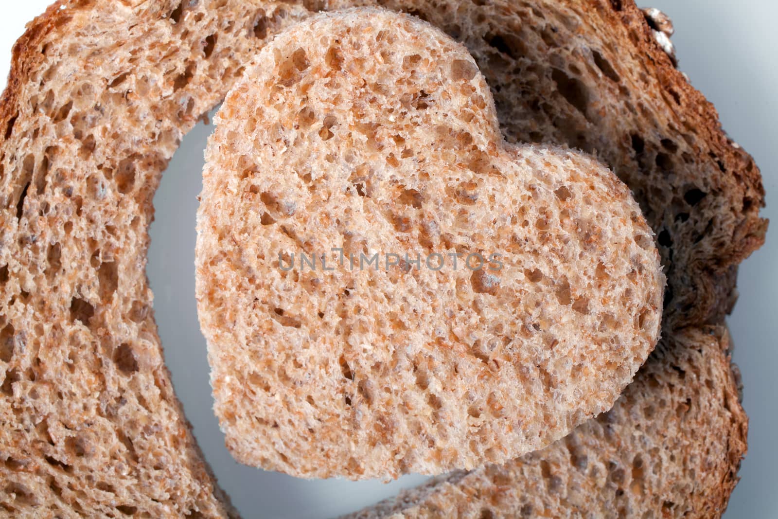 Piece of bread toast cut hole in shape of heart Isolated on white background