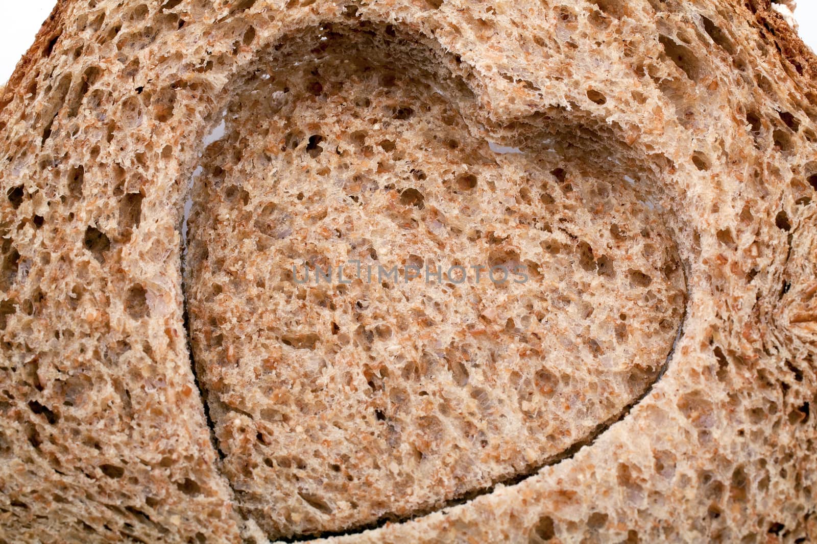 Heart shaped hole in a slice of bread by Portokalis