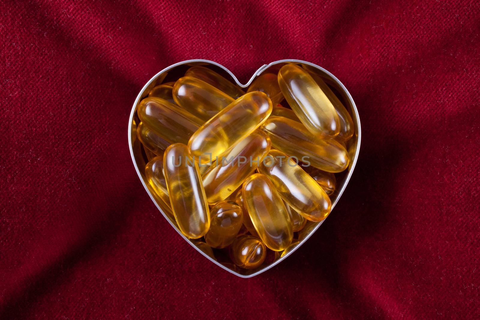 Vitamin capsules arranged in the shape of a heart to portray the concept of a healthy heart and lifestyle