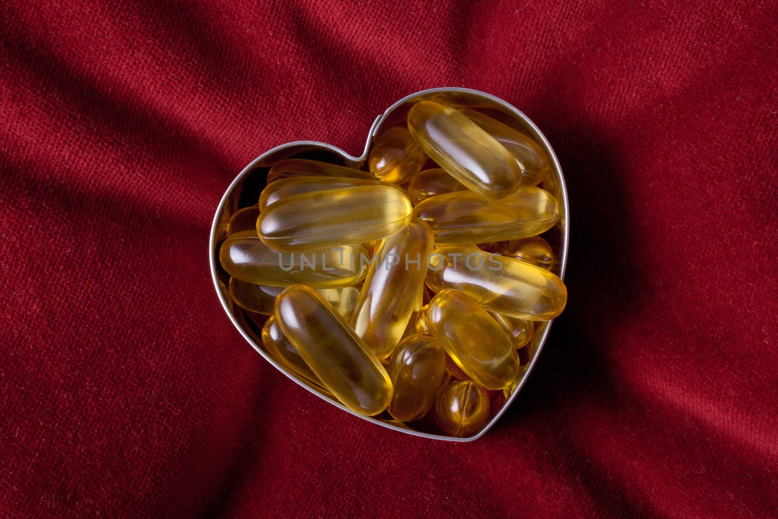 Vitamin capsules arranged in the shape of a heart to portray the concept of a healthy heart and lifestyle