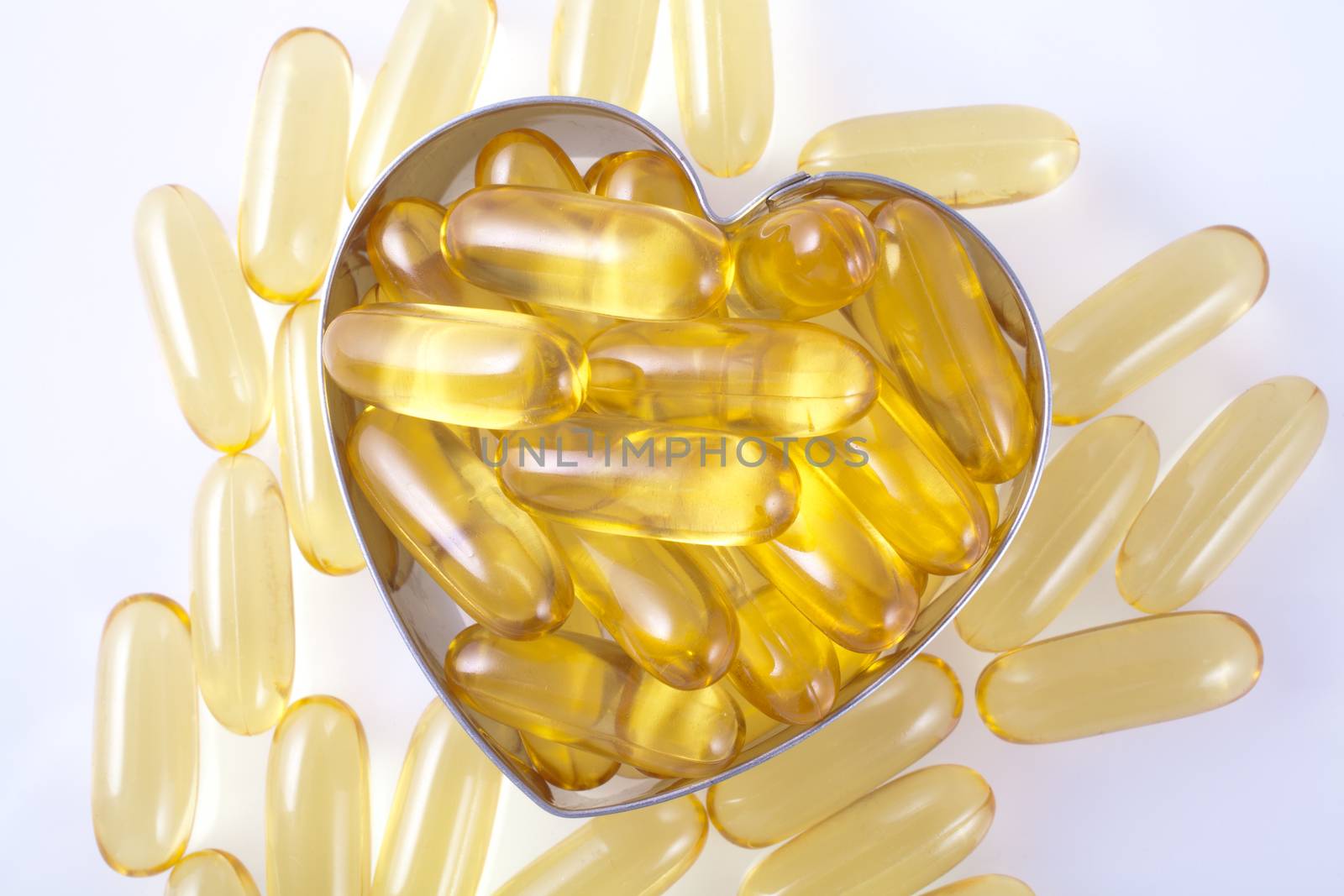 Vitamin capsules arranged in the shape of a heart to portray the concept of a healthy heart and lifestyle