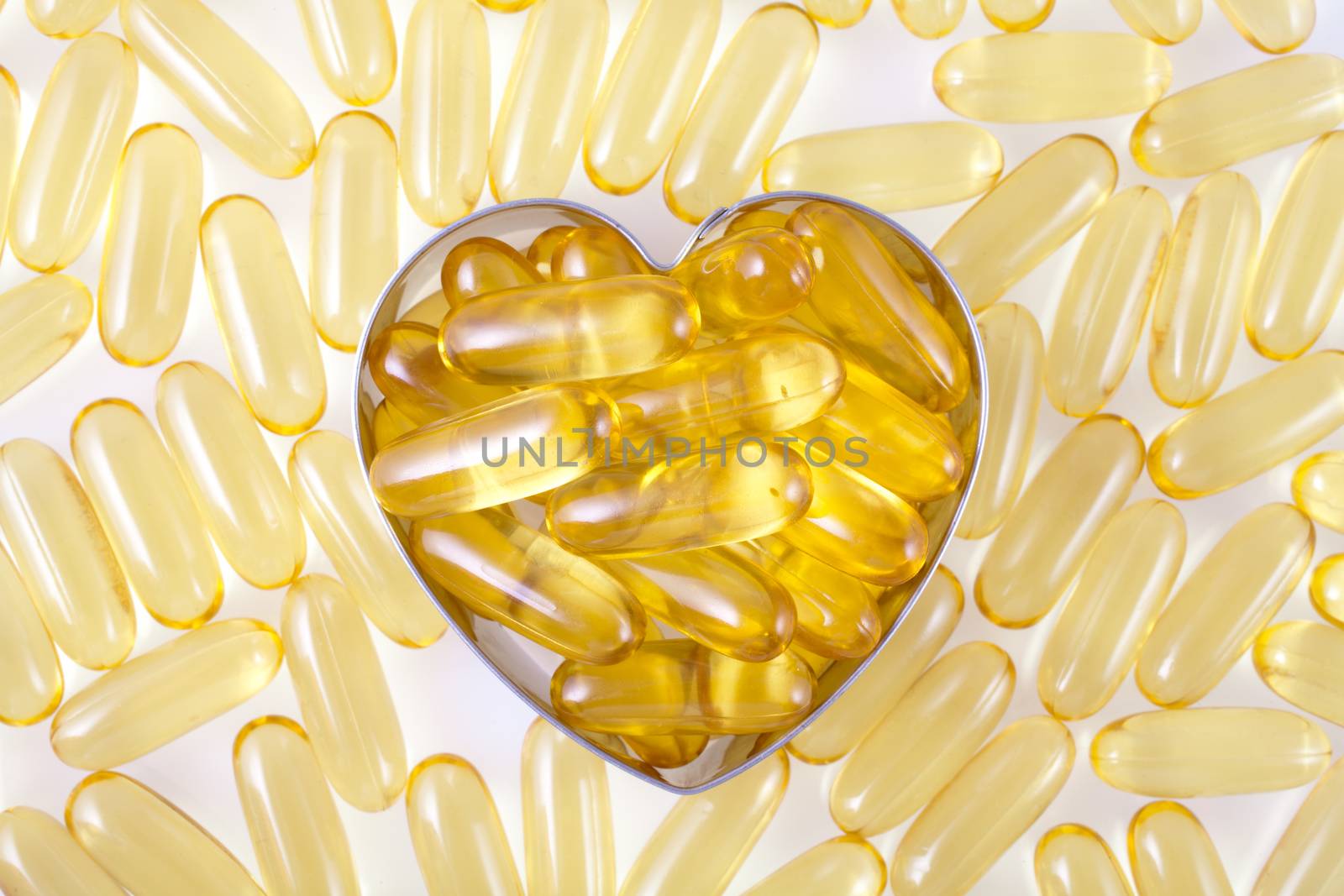 Vitamin capsules arranged in the shape of a heart by Portokalis