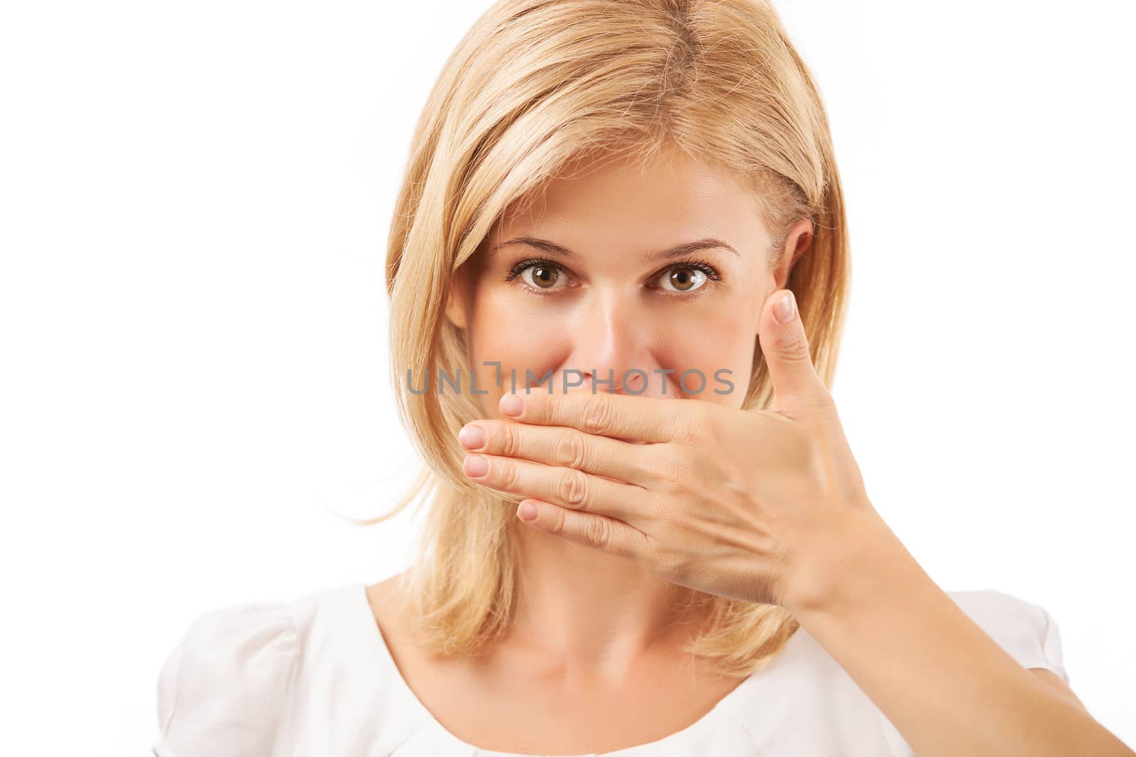 Smiling young woman covering mouth over white background