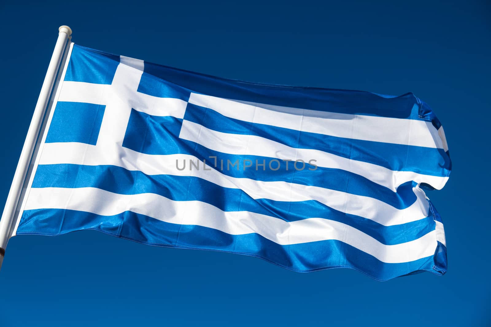 Greek flag in the wind against the blue sky