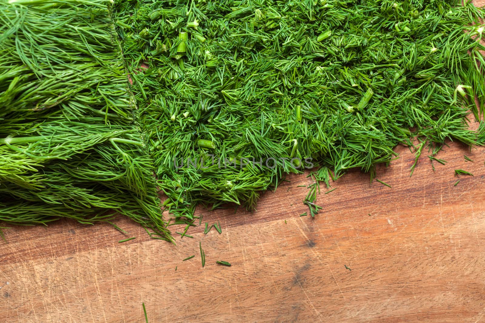 Fresh dill sprigs on wooden board cutting with knife