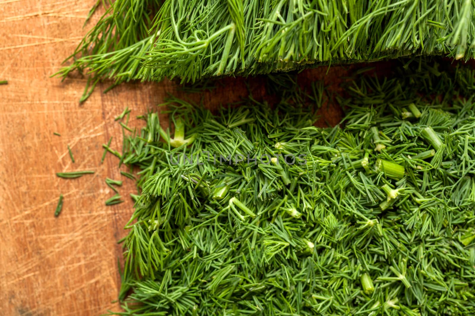 Fresh dill sprigs on wooden board cutting with knife