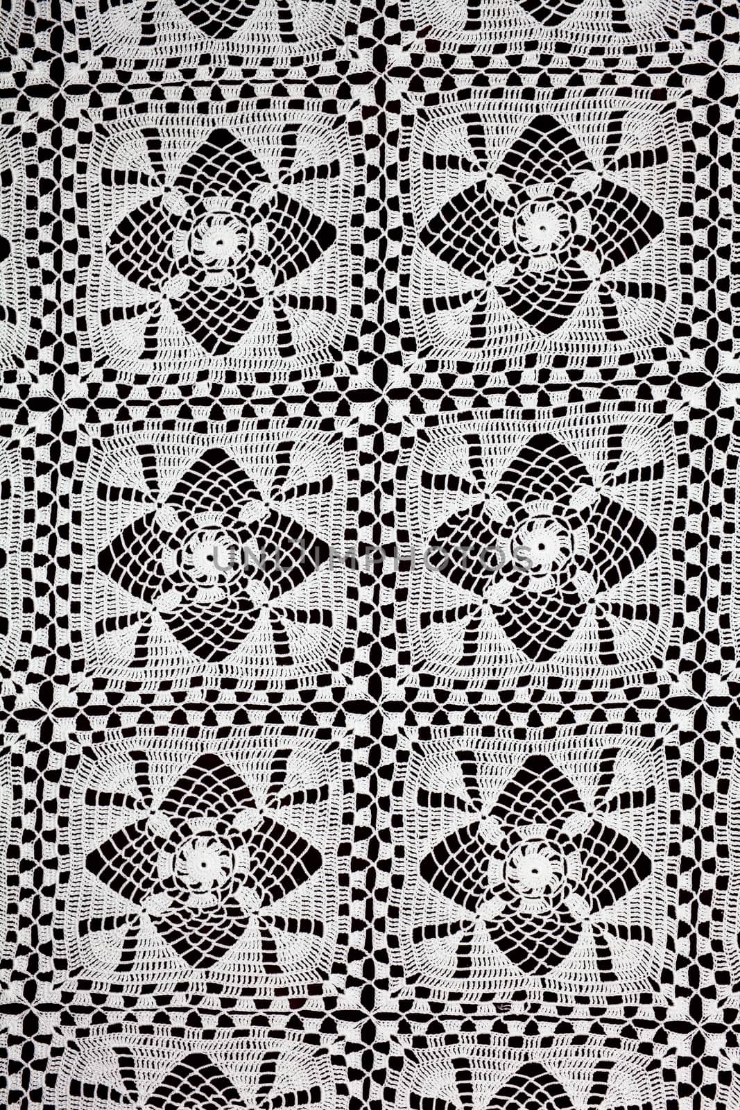 Handmade white lace doily runner on a black background