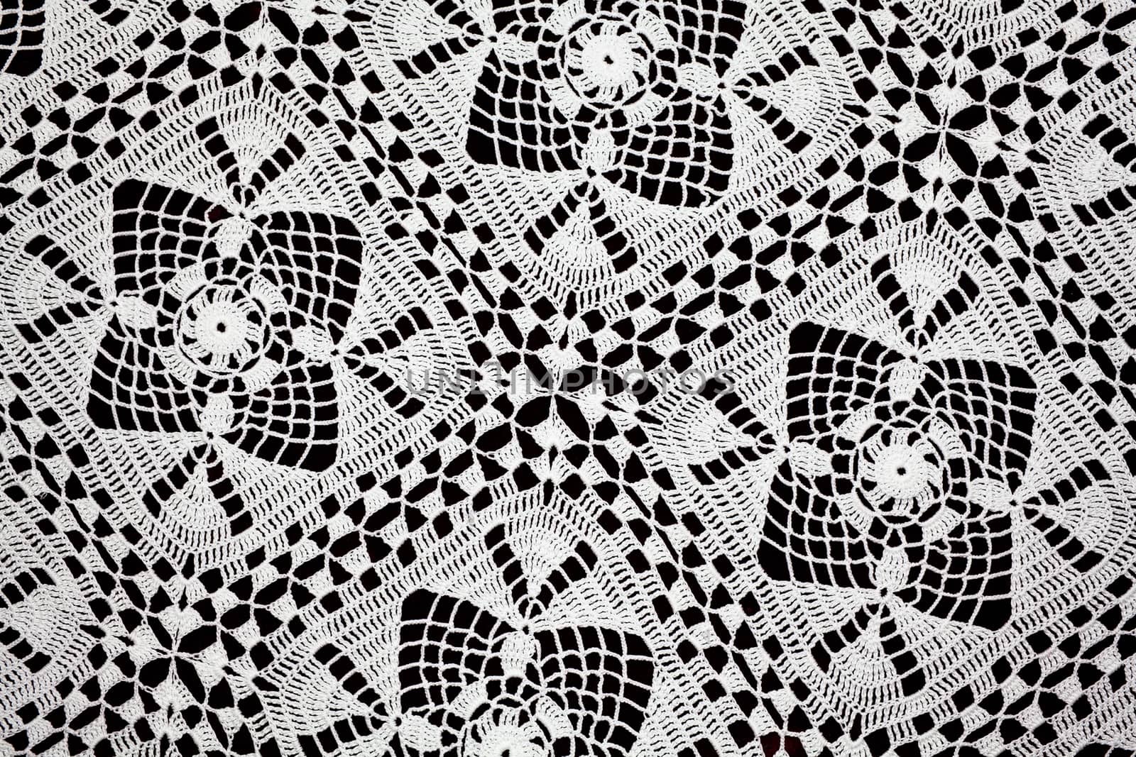 Handmade white lace doily runner on a black background