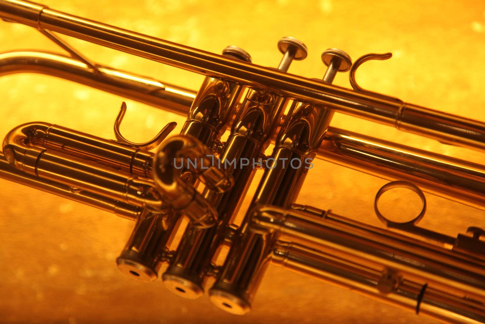 Brass trumpet horn on a golden background. Soft light photograph.