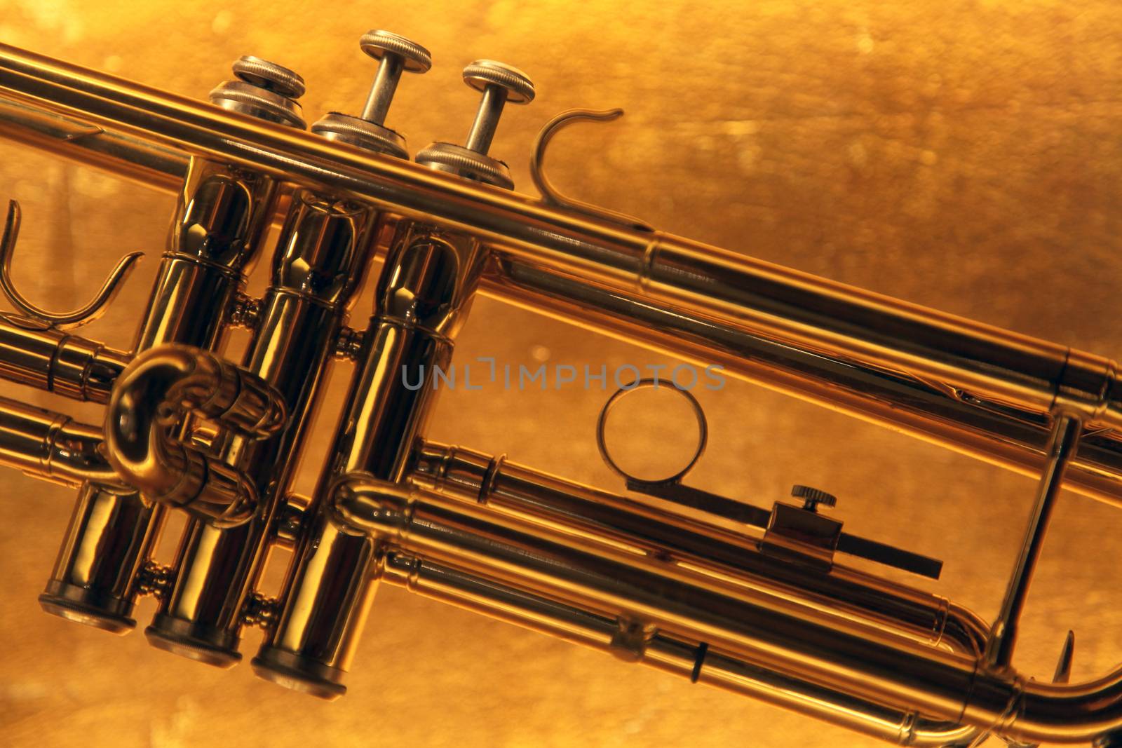 Brass trumpet horn on a golden background. Soft light photograph.