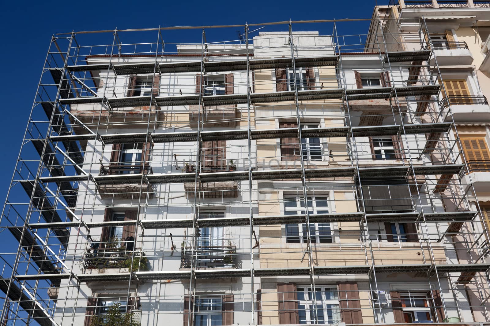 Old building under renovation. Scaffolding placed around the facades