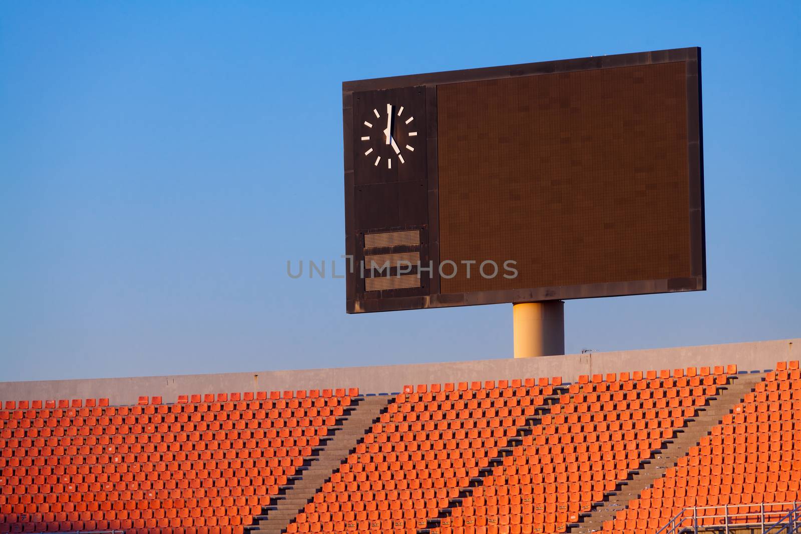 Scoreboard and bleachers in blue sky