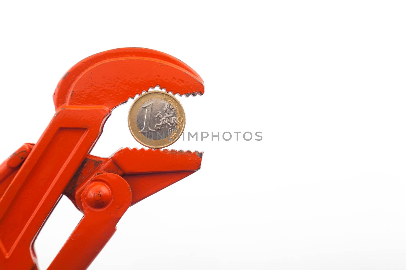 Financial crisis, euro in press, economy concept. Orange wrench pressing a euro coin