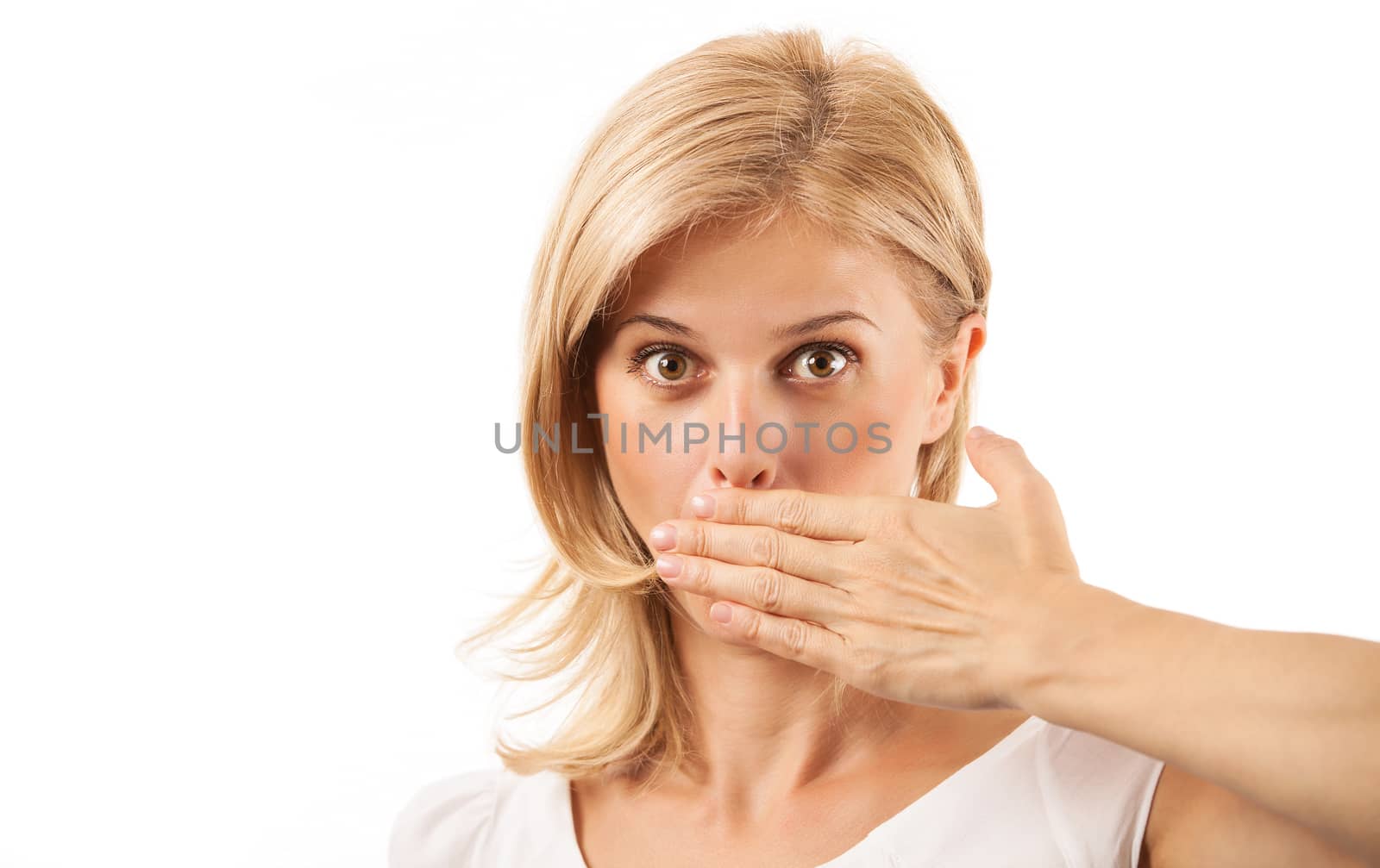 Amazed young woman covering mouth over white background