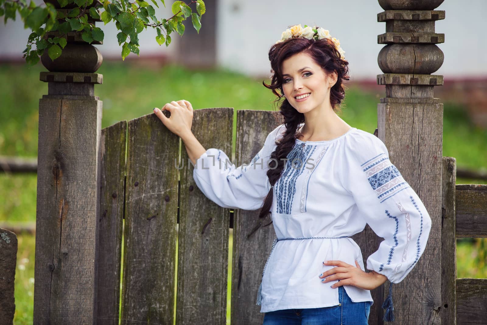 Young woman in Ukrainian style clothing outdoors by photobac