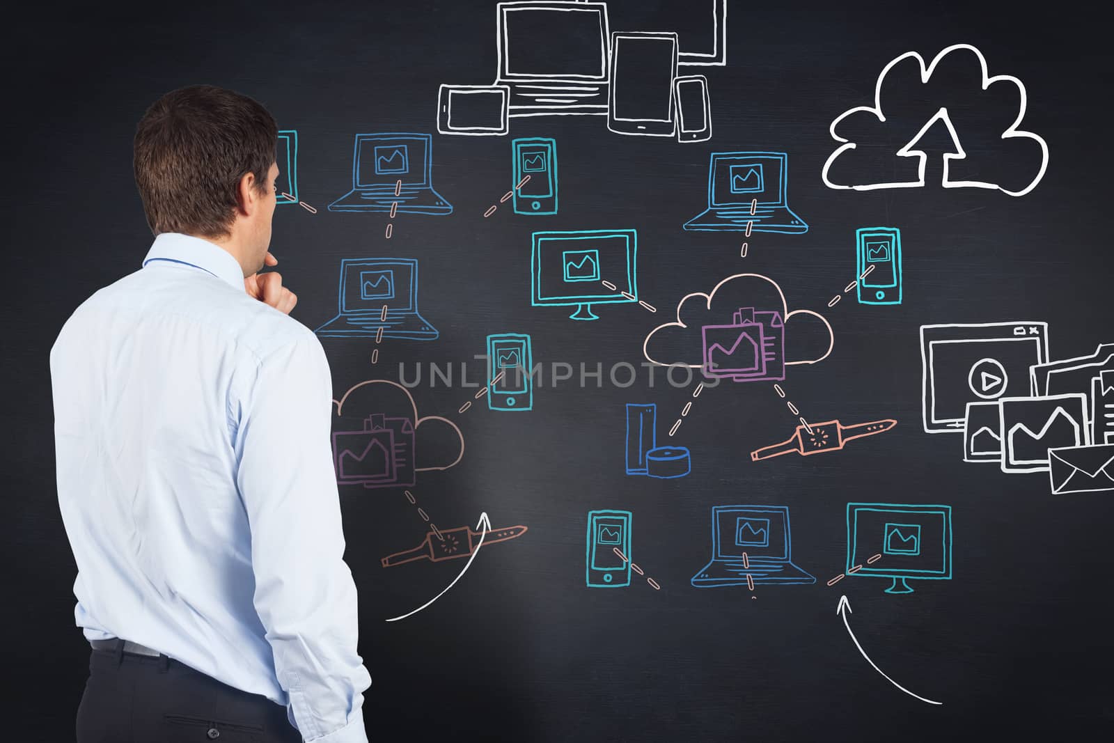 Thinking businessman touching his chin against blackboard with technology doodles