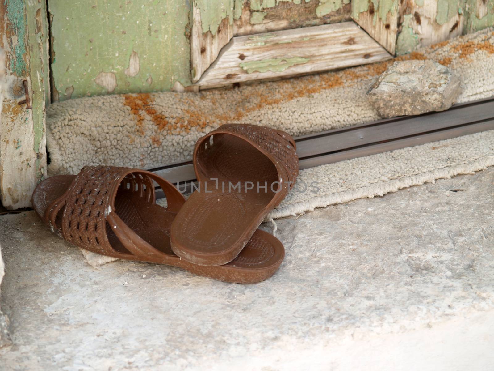 A pair of old plastic slippers at the doorstep outside an old house in Pirgi of Chios island - Greece