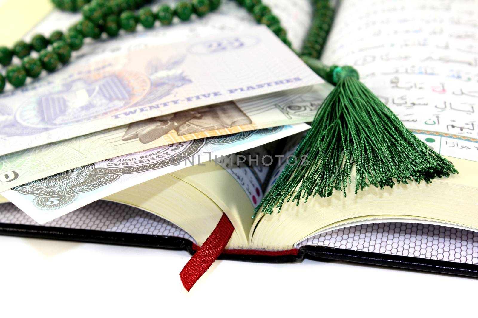 whipped Quran with Egyptian currency before light background