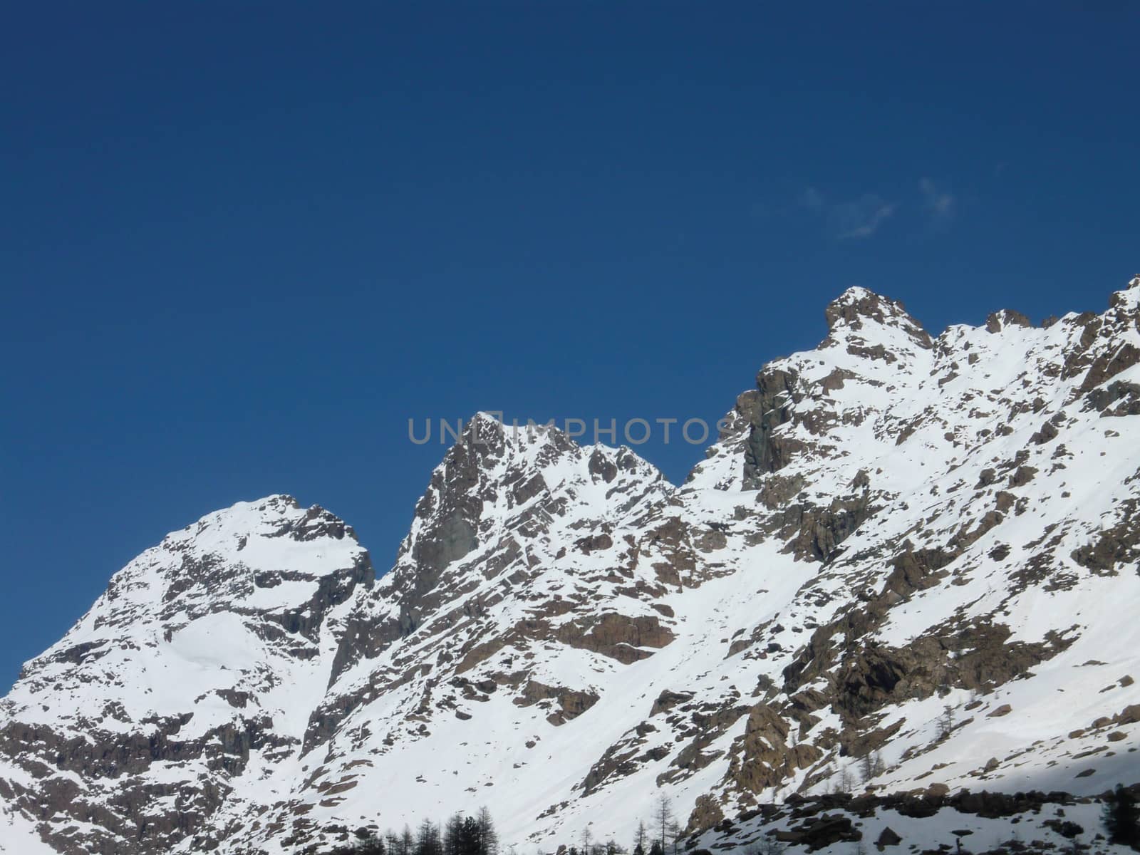 Mountain snowy peaks of the Alps on Spring. Red rocks (iron inside). Hiking, mountain running, mountaineering and other outdoor activities. Corni bruciati, Preda Rossa, Val Masino, Lombardy, Italy