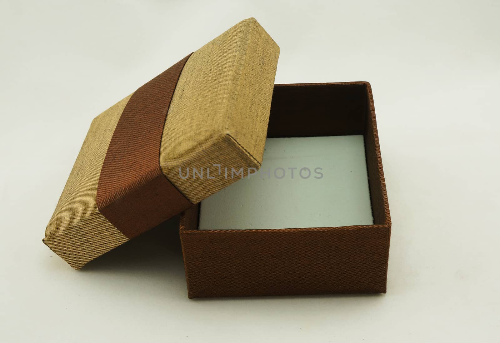Opened gift box packaging, the exterior is made from fabric with gold and brown color.                               