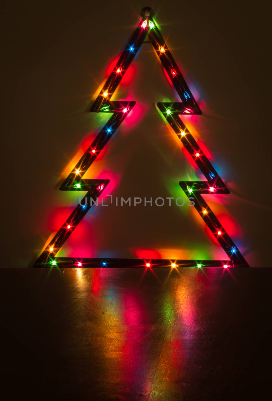 Christmas lights on a Christmas tree and its reflection