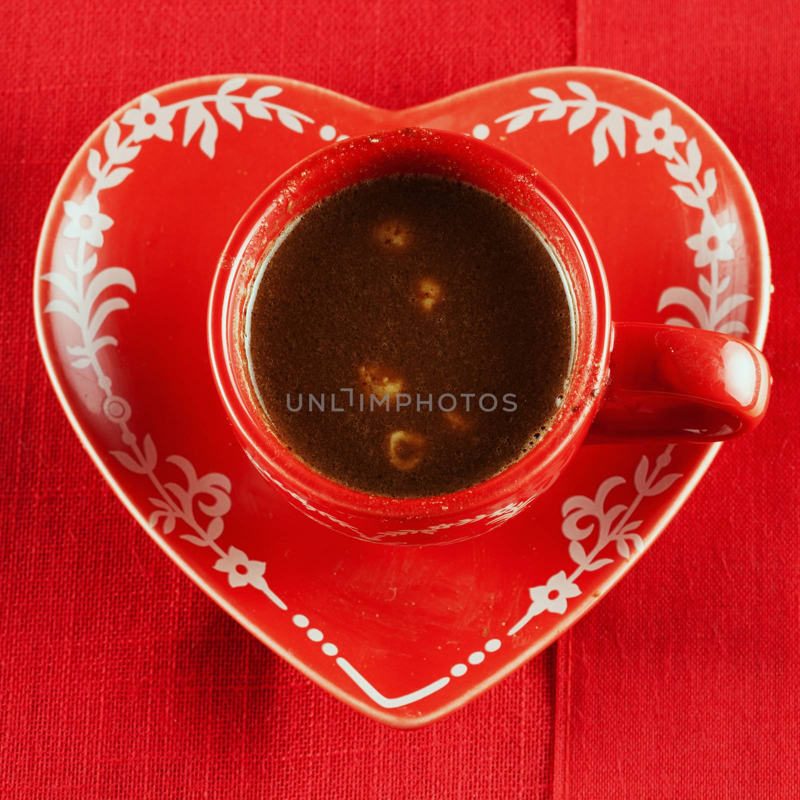 Chocolate and hazelnuts in red cup, over red cloth